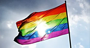 rainbow gay pride flag with sun shining on it