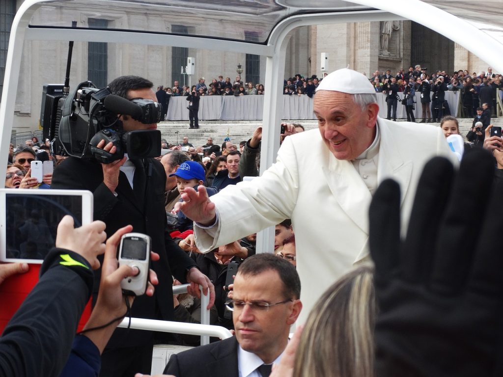 Pope Francis waving at crowd from Pope Mobile