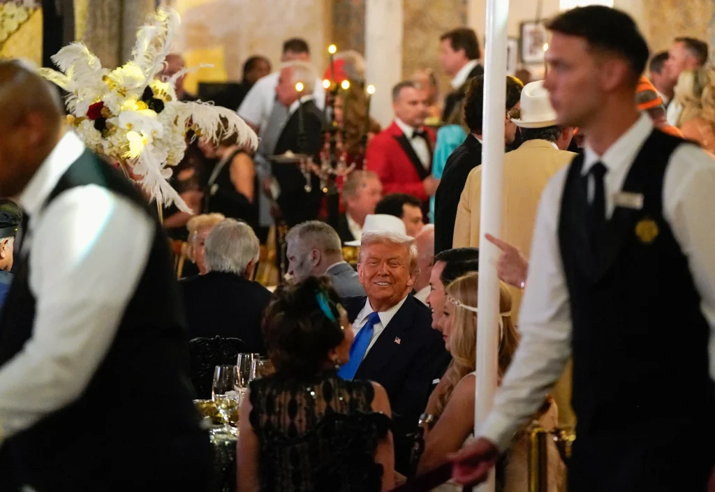 trump sitting in Mar-a-Lago during his Great Gatsby themed party .